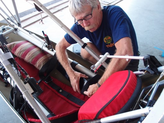 Ken Dawe mounts one of two battery packs.  Large tubes on either side of pilot mark the structure's hang-gliding heritage